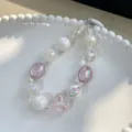 Elegant sweet iridescent beaded phone charm featuring a pink heart pendant on a plate. - Light Purple