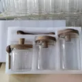 Vue détaillée de pots de stockage en verre transparent avec couvercles en bois. - Lot de 3 pièces en mousse EPE