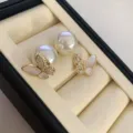 Detailed close-up view of elegant butterfly stud earrings with pearls and zircon stones. - Mother Of Pearl Artificial Pearl Studs (R3050)