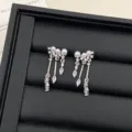 Nahaufnahme eleganter silberner Ohrhänger mit weißen Perlen und funkelnden Kristallen - R2248 Perlen Quasten Ohrstecker