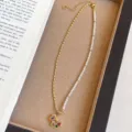 Elegante asymmetrische Perlen- und Goldkette mit buntem Trojaner-Pferd-Anhänger. - Halskette / Vergoldung / Gold & Weiß & Mehrfarbig