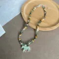 Gedetailleerd overzicht van een boheemse kralenketting met groen gestreepte zebra-hanger - Zilver en Groen
