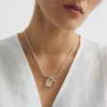 Primer plano de un collar minimalista de plata con colgante de cristal transparente. - Collar