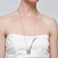 Detailweergave van een minimalistische zilveren madeliefje ketting gedragen door model - Ketting