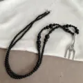 Macro shot of a niche black bead necklace featuring a creative silver fork pendant detail. - Black Bead Fork Style (ML1227) / Silver/Black