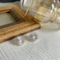 Gros plan de boucles d'oreilles fleurs sauvages minimalistes avec perles sur tissu - Blanc (Style Perle)