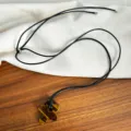 Detailed view of natural tiger's eye stone flower pendant on a minimalist black cord - Tiger Eye Flower
