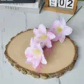 Close-up of artificial pink lily branch with oil painting texture on wooden slice - Pink