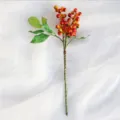 Vue en détail d'une branche de baies artificielles rouges pour décoration de fêtes. - Orange