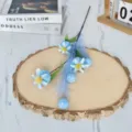 Vue détaillée d'une branche de gousse de pavot bleue artificielle sur une tranche de bois - Bleu