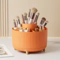 Orange rotating makeup organizer with vertical stripes and decorative gold legs - Orange