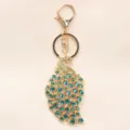 Luxe pauw sleutelhanger met blauwgroene en groene strasstenen in goudkleurige legering. - Groen
