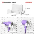 White wall-mounted hairdryer holder for pegboard with dimensions and usage example - Hairdryer Holder / 18.5x10.5x9.3cm