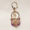 Vintage style fox mask keychain with colorful crystals and gold-plated hardware on fabric. - Purple