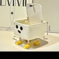 Cream white mini desktop trash can featuring a cute cartoon face, lid, and four yellow feet - Low Standing Style with Lid (Four Feet + Dot Eyes)