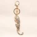 Elegant gold-plated leopard charm keychain featuring sparkling white and black crystals - Gold