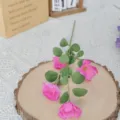 Detaillierte Nahaufnahme von pinken Seidenkosmosblüten auf einer rustikalen Holzscheibe. - 4-Kopf Cosmos / Fuchsia