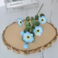 Vista detallada de flores de cosmos azul claro artificiales con hojas de eucalipto - Azul