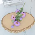 Primer plano de flores cosmos púrpuras artificiales con hojas verdes de eucalipto en madera - Púrpura