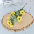 Vue détaillée d'une branche de marguerite jaune artificielle sur un socle en bois - Jaune