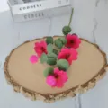 Gros plan de fleurs de cosmos magenta artificielles avec feuilles d'eucalyptus sur bois. - Rose rouge