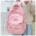 Detail of pink leopard print backpack with multiple zip compartments and logo label. - Pink