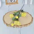 Detailed view of yellow 3-head artificial poppy stem with leaves on wooden slice - Yellow
