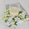 Detail van gesimuleerde wilde bloemen kaars krans met LED kaars op marmeren blad - Wit
