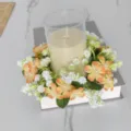Pastorale wilde bloemen kaarsenring met glazen houder op een decoratieve boeksteun - Oranje