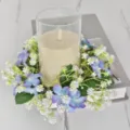 Detail van kunstmatige wilde bloemen kaarsenkrans met glazen houder op marmeren tafel - Blauw