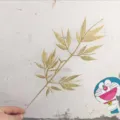 Gold glitter artificial bamboo leaves branch for Christmas tree decoration and festive home floral arrangements. - Gold