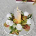 Detailed view of LED candle with white rose floral wreath and autumn leaves for wedding decor. - White