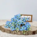Detailed view of blue artificial paulownia flowers bouquet on wood slice for home decor. - Sky Blue