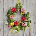 Gedetailleerd zicht op een levendige kunstmatige veldbloemenkrans op een houten wand - Kleurrijke Krans