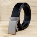 Detail view of a men's black genuine leather belt with a matte silver automatic buckle. - Black (Style 02) / 110cm