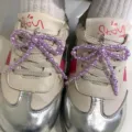 Close-up of purple pearl bow shoe charms attached to sneaker laces for decoration. - Beaded Bowknot (R5050) / One Pair / Purple