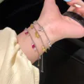 Dettaglio della collana in argento con cristalli di zircone a goccia indossata al polso - Bracciale Retrattile a Goccia d'Acqua (R0195) / Rosso rosa