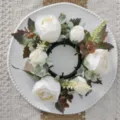 Top view of artificial white rose and maple leaf wreath on a white decorative plate - Artificial Rose Maple Wreath / White