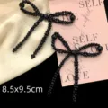 Detailed close-up of a elegant black beaded bow shoe charm clip, measuring 8.5x9.5cm - Black High-Gloss Beaded Bowknot Style (R1782) / 1 Pair / Black