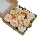 Gros plan d'une boîte de fleurs artificielles avec des pivoines et des roses pêche - Rose Champagne