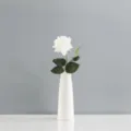 Vue détaillée d'une seule rose artificielle blanche à texture humide réaliste. - Blanc