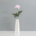Détail d'une rose artificielle rose au toucher naturel placée dans un vase blanc minimaliste - Rose Crème