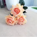Gros plan de trois roses artificielles champagne sur une texture de jute rustique. - Orange