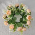 Detailed top-down view of a peach tea rose and white baby's breath floral candle wreath - Champagne