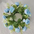 Top-down view of a decorative blue tea rose and baby's breath candle ring wreath - Blue