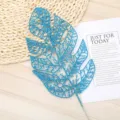 Blue glitter artificial monstera leaf detail shot, perfect for floral arrangement decor. - Blue