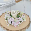 Gros plan détail d'une couronne de bougie de fleurs artificielles roses et blanches sur bois. - Rose Clair