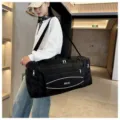 Vue détaillée du grand sac de voyage de sport noir, tissu durable avec sangles et poches. - S / Noir
