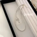 Macro view of a 6mm minimalist white pearl necklace presented in a jewelry box tray. - Necklace (A73)