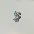 Primo piano dettagliato di un orecchino a farfalla blu con pietre scintillanti - Stile Fiocco (A13) / 1 Pezzo (7mm)